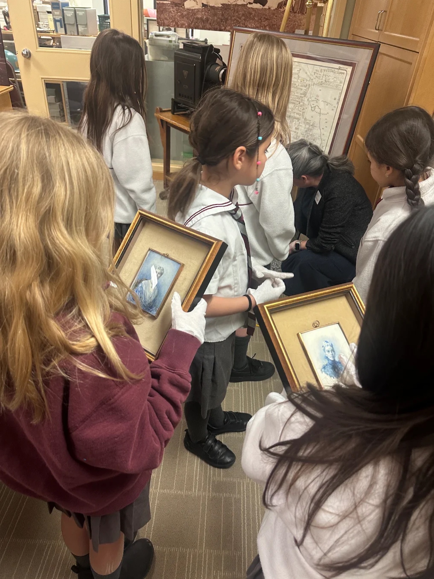Students examining miniature portraits
