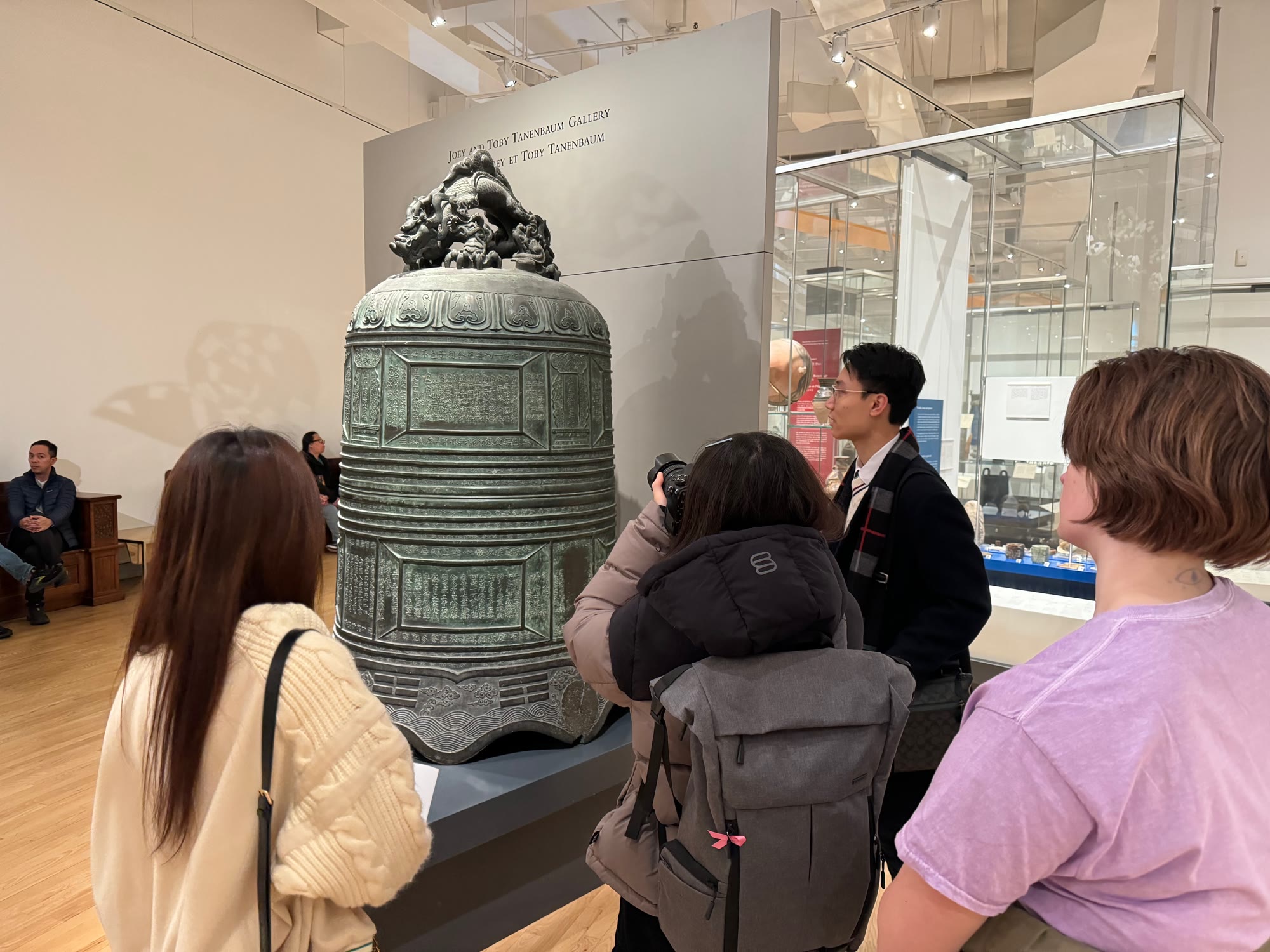 Club members around a bronze temple bell